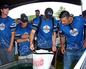 Mark Zona checks out eventual winner Don Watts (2nd from left) big Kent Lake bass during the June 10th 2013 KVD Charity Classic charity bass fishing tournament