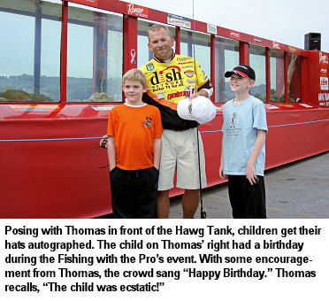 Posing with Thomas in front of the Hawg Tank, children get their hats autographed. The child on Thomas' right had a birthday during the Fish with the Pros event. With some encouragement from Thomas, the crowd sang Happy Birthday. Thomas recalls, 