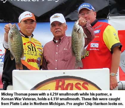 Mickey Thomas poses with a 4.21 pound smallmouth while his partner, a Korean War Veteran, holds a 4.11 pound bass. These fish were caught from Platte Lake in Northern Michigan. Pro angler Chip Harrison looks on.