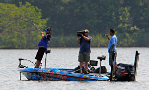 Legendary bass pro Denny Brauer maintains a strong lead on day three of the 2011 Elite Series Diamond Drive on the Arkansas River hooking a bass in front of Mark Zona and cameraman James Massey
