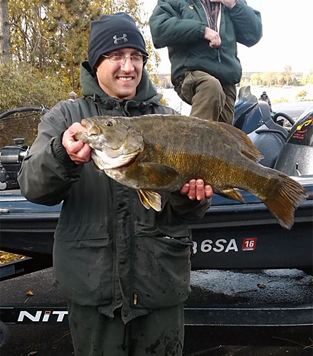 Michigan bass tournament angler Greg Gasiciel shows his record-sized 9.32 pounds smallmouth bass he caught fishing the Hubbard Lake Open. Photo credit: Bill McQuarrie