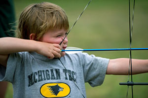 Photo of a young boy shooting a bow and arrow. Archery is one of the many DNR-sponsored activities families can enjoy during Detroit River Days.