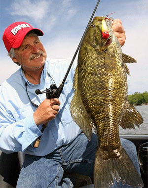 Minnesota bass fishing ace Scott Bonnema shows off a big post-spawn smallmouth bass that fell for a topwater popper