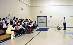 Dan Kimmel speaking to students in their gymnasium